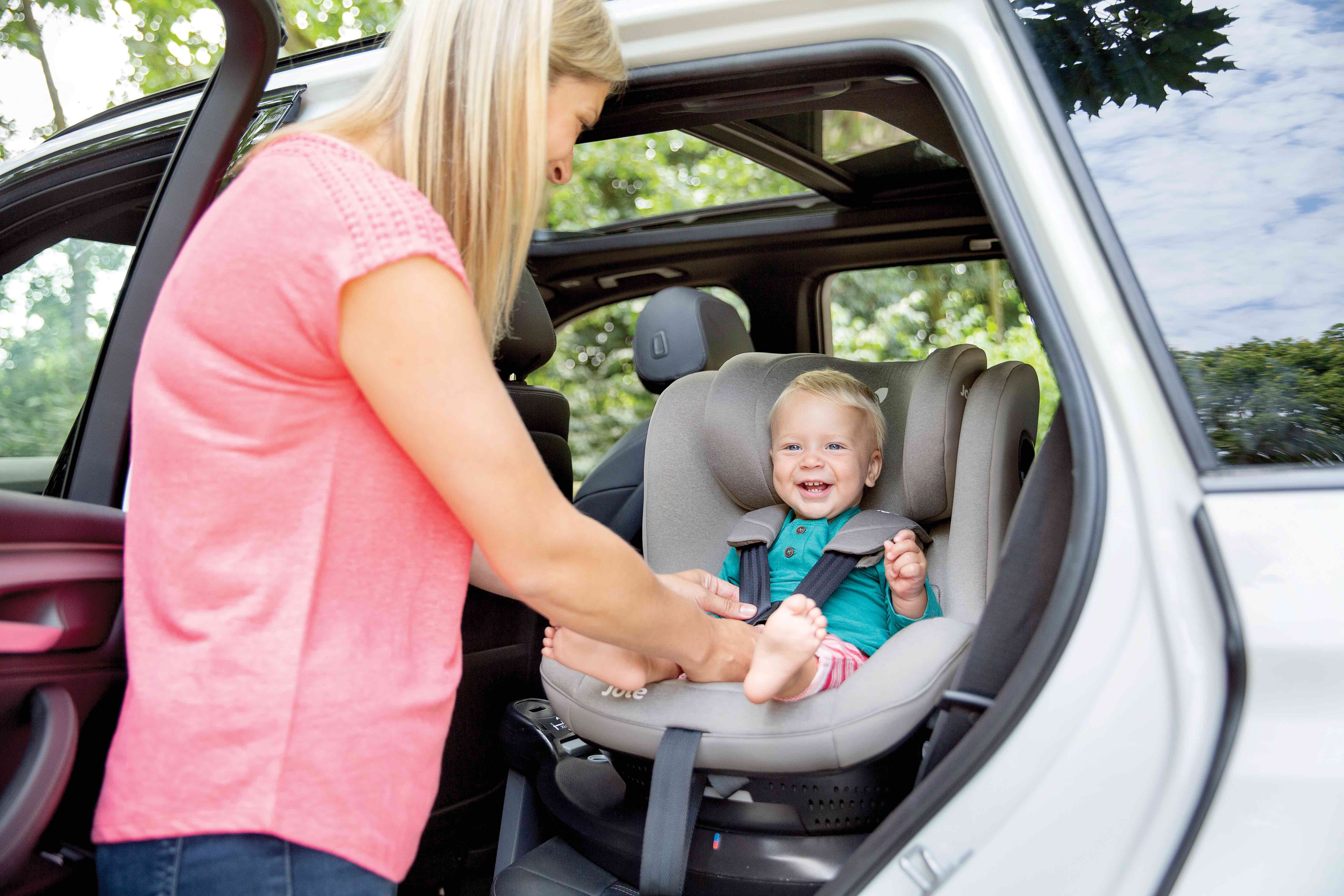 Une maman installe son enfant dans un siège auto