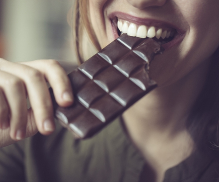 femme qui croque dans une tablette de chocolat