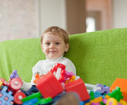 Un enfant est assis face à une pile de jouets 