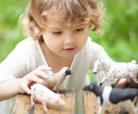 petite fille jouant avec figurines animaux de la ferme