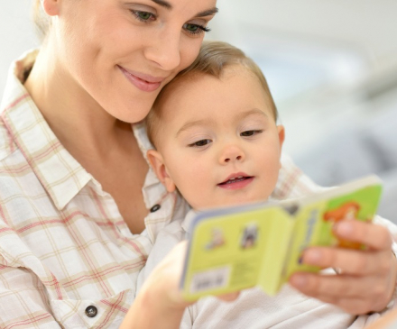 Assistante maternelle qui lit un livre à un bébé