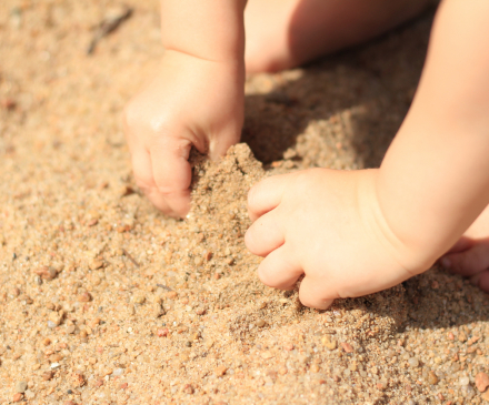 mains bébé dans le sable