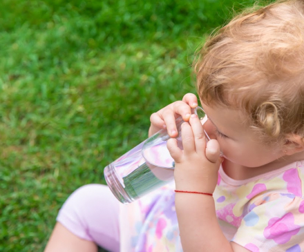 jeune enfant buvant de l'eau en été 