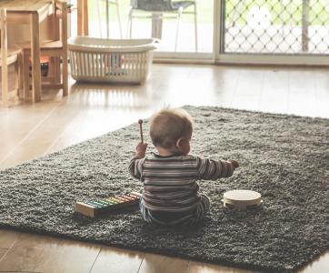 Bébé jouant sur un tapis avec des instruments de musique dans une crèche