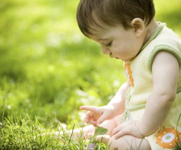un bébé joue dans l'herbe