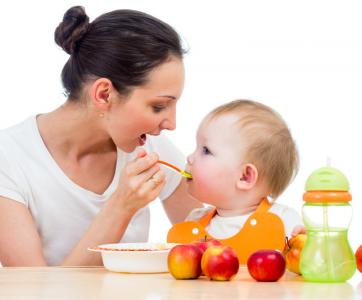 bébé mange avec so,n assistante maternelle