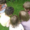 5 enfants accroupis dans l'herbe