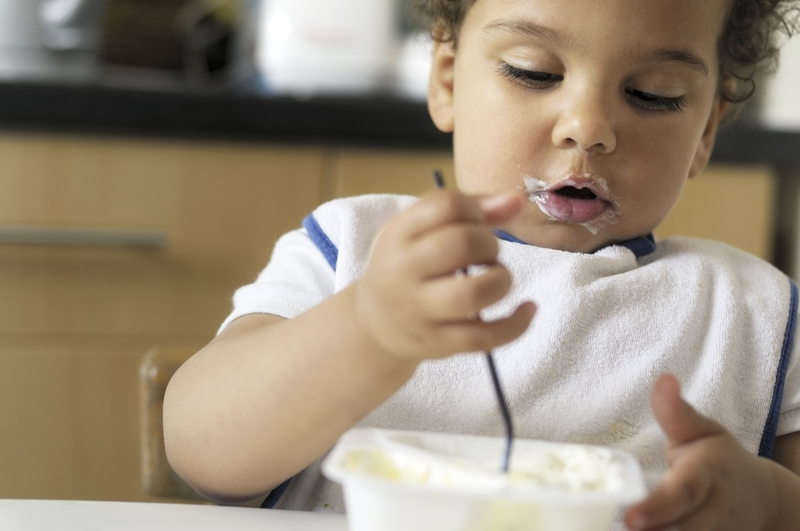 Enfant qui mange un yaourt